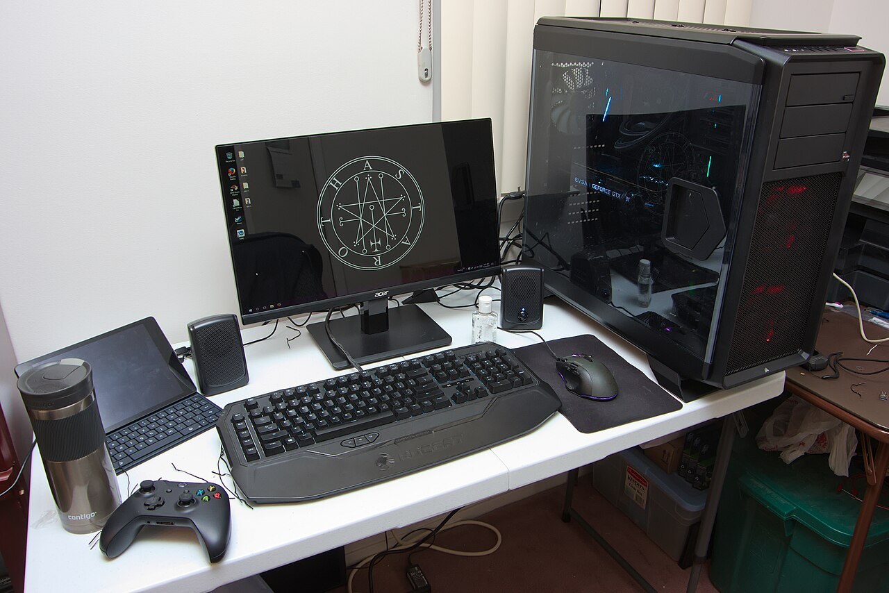 A desktop gaming computer beside its monitor and peripherals