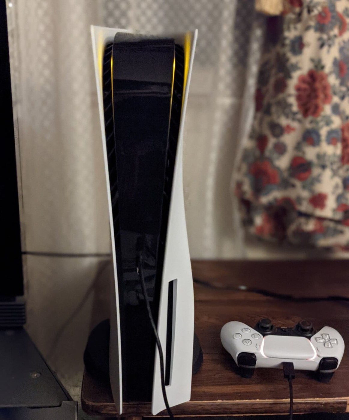 PlayStation 5 console standing beside a DualSense controller